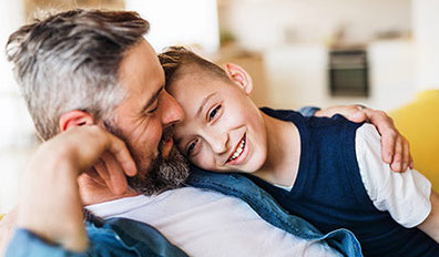 happy father and son sitting on couch