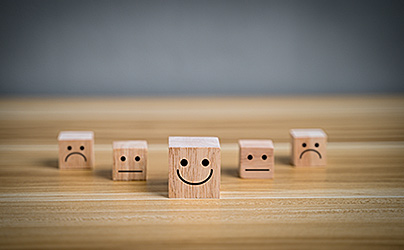 wooden blocks with sad and happy faces